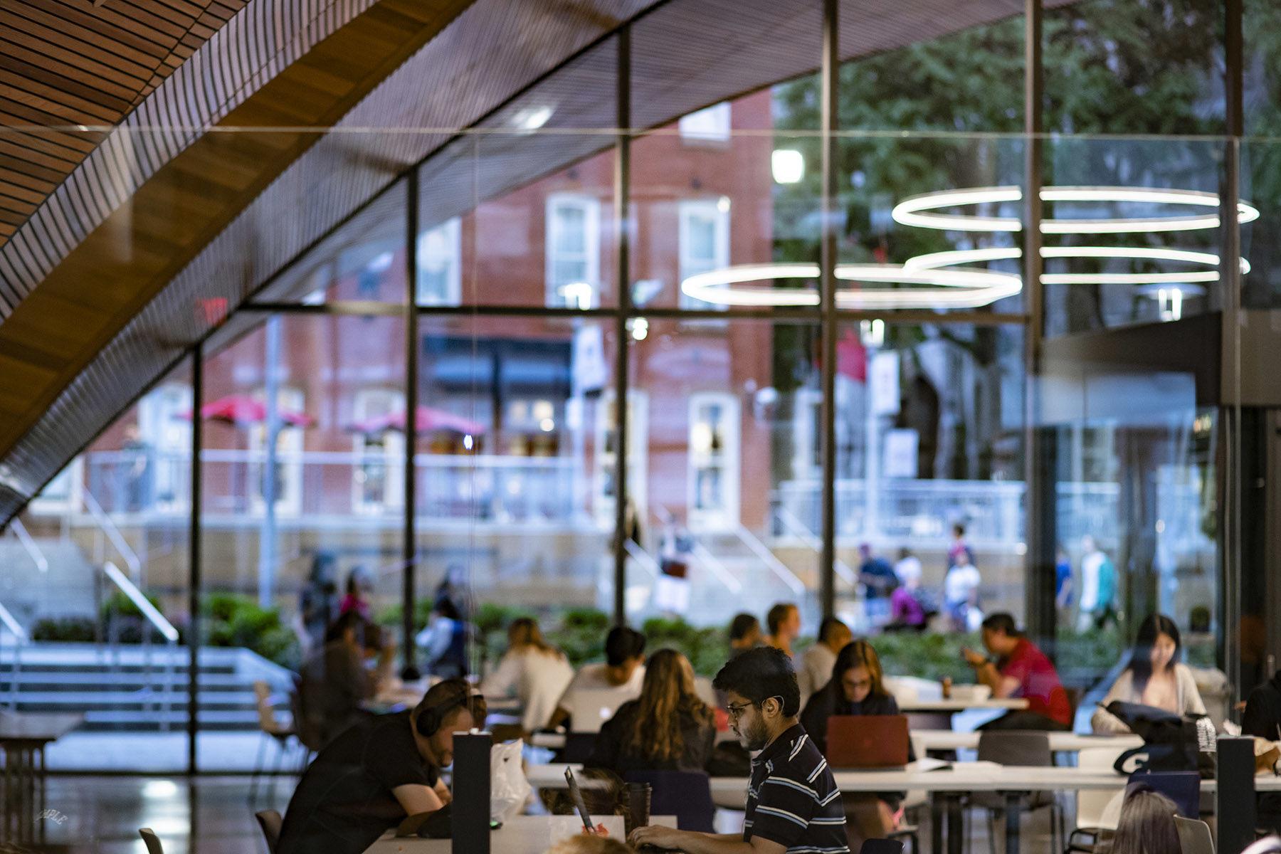 students studying in Charles Library with windows facing out to Liacouras Walk